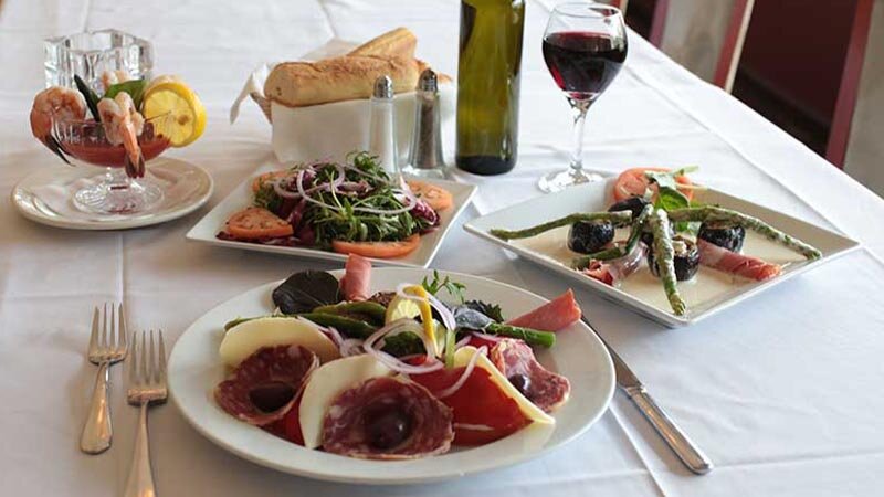Multiple salads and appetizers with focus on antipasto salad