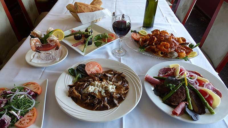 Multiple entrees with red wine and appetizers